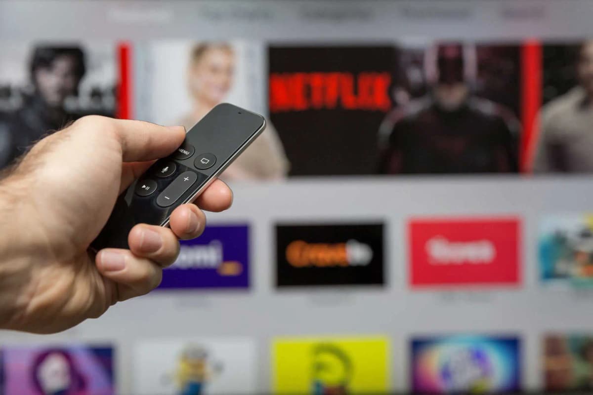 L'application IPTV, interface du service Télécommande pointée vers un téléviseur affichant une application IPTV